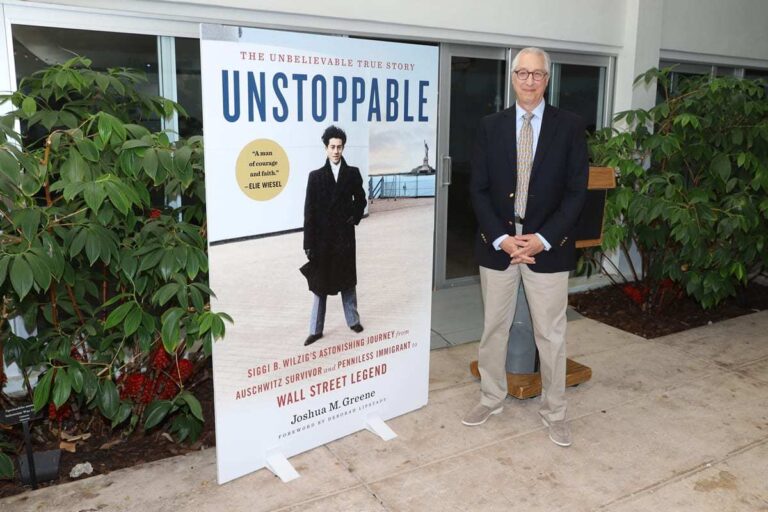 Joshua M. Greene posing with book cover